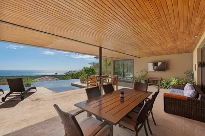 a dining room with a wooden table and chairs at Serene Oceanview Villa with Pool in Playa Flamingo