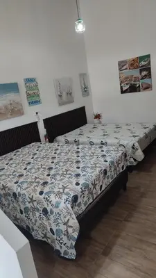 a bedroom with a bed with a blue and white comforter at Ecohacienda Perla Marina in Sardinal