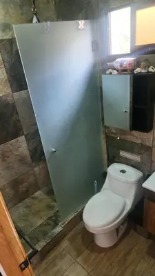 a bathroom with a toilet and a green wall at Ecohacienda Perla Marina in Sardinal