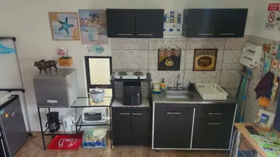 a small kitchen with black cabinets and a sink at Ecohacienda Perla Marina in Sardinal