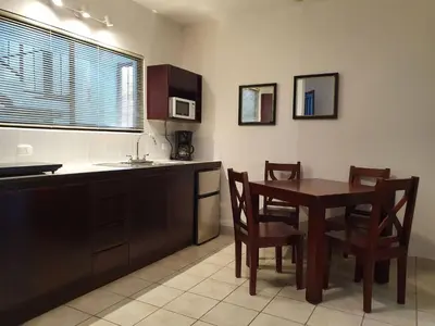 a kitchen with a table and chairs and a kitchen with a sink at Apart Hotel Marina Loft 101 in Coco