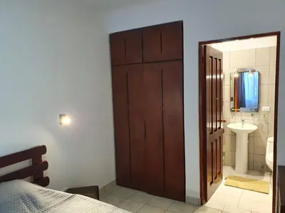 a bedroom with a door leading to a bathroom with a sink at Apart Hotel Marina Loft 101 in Coco