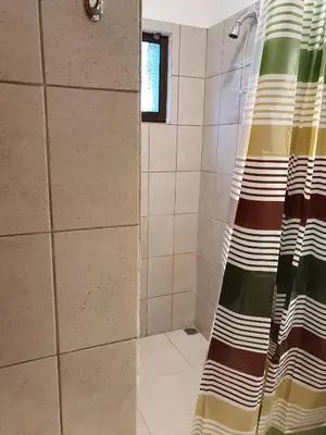 a shower with a shower curtain in a bathroom at Apart Hotel Marina Loft 101 in Coco