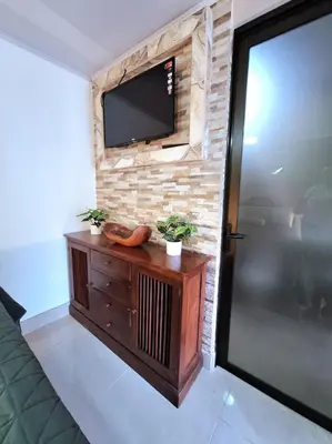 a living room with a television on a brick wall at Apartamento Studio cerca de Playa Tamarindo in Villarreal