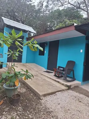 a blue house with a chair in front of it at Apartamento Studio cerca de Playa Tamarindo in Villarreal