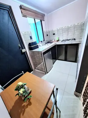 a small kitchen with a wooden table and a dining room at Apartamento Studio cerca de Playa Tamarindo in Villarreal