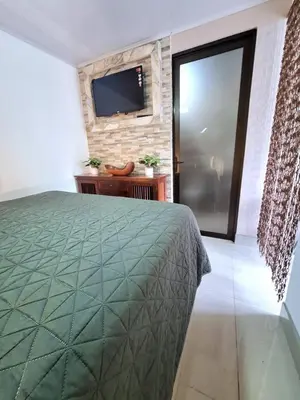 a bedroom with a bed and a television on a wall at Apartamento Studio cerca de Playa Tamarindo in Villarreal