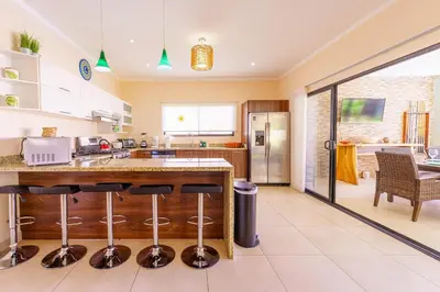 a kitchen with a counter with stools at Casa Mimi - Beautiful House In Surfside in Potrero