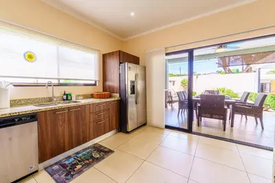 a kitchen with a large glass door leading to a dining room at Casa Mimi - Beautiful House In Surfside in Potrero