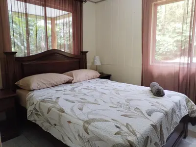 a bedroom with a large bed with a window at Mini reserva La Naciente Mi casa es tu casa in Tapantí