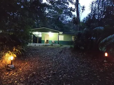 a house at night with lights in the yard at Mini reserva La Naciente Mi casa es tu casa in Tapantí