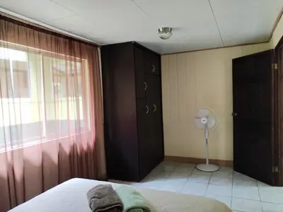 a bedroom with a bed and a window and a fan at Mini reserva La Naciente Mi casa es tu casa in Tapantí