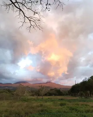 a cloudy sky with mountains in the distance at Mini reserva La Naciente Mi casa es tu casa in Tapantí