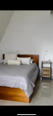 a bedroom with a large bed with a wooden headboard at Moonlight Lodge in Cuatro Esquinas