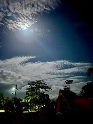 a blue sky with the sun and clouds in the sky at Moonlight Lodge in Cuatro Esquinas