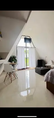 a bedroom with a bed and a table and a window at Moonlight Lodge in Cuatro Esquinas