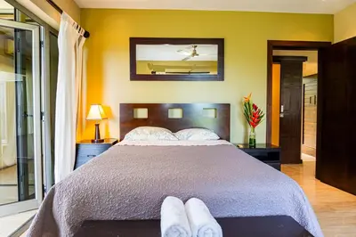 a bedroom with a large bed with two pairs of shoes on it at Unique panoramic view and Central location! in Uvita
