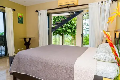 a bedroom with a bed and a large window at Unique panoramic view and Central location! in Uvita
