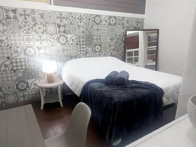 a bedroom with a bed and a table with a lamp at Vintage and Colonial House - 7min from Airport in Alajuela City