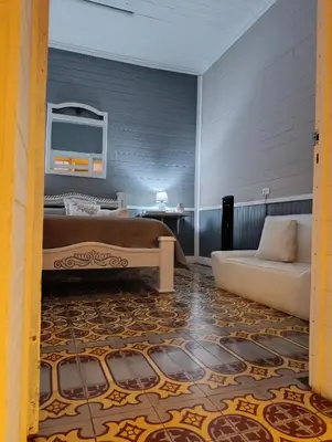 a living room with a bed and a couch at Vintage and Colonial House - 7min from Airport in Alajuela City