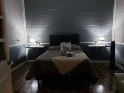 a bedroom with a large bed with two night stands at Vintage and Colonial House - 7min from Airport in Alajuela City