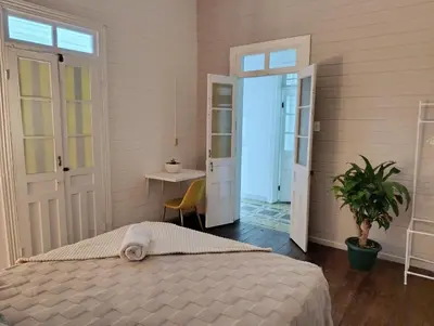 a bedroom with a bed and a table and a desk at Vintage and Colonial House - 7min from Airport in Alajuela City