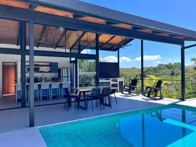 a house with a swimming pool and a dining room and kitchen at Guanacaste Marbella luxury home with a private pool in Santa Cruz