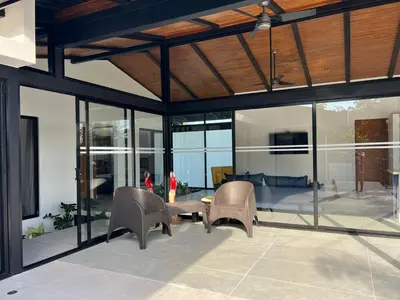 a living room with glass walls and a table and chairs at Guanacaste Marbella luxury home with a private pool in Santa Cruz