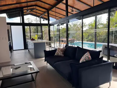 a living room with a blue couch and a table at Guanacaste Marbella luxury home with a private pool in Santa Cruz