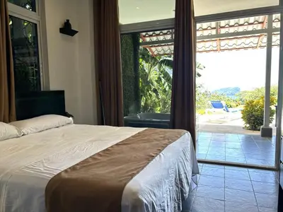 a bedroom with a bed and a large sliding glass door at Manuel Antonio Appartement 4 personnes Terrasse priv in Quepos