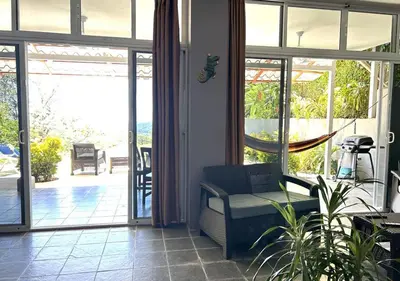 a living room with a couch and a sliding glass door at Manuel Antonio Appartement 4 personnes Terrasse priv in Quepos