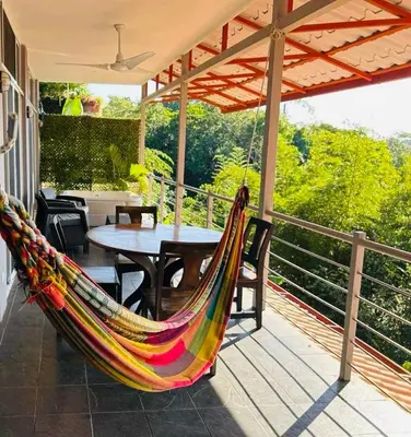 a hammock on a porch with a table and chairs at Manuel Antonio Appartement 4 personnes Terrasse priv in Quepos