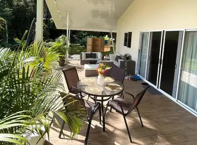 a patio with a table and chairs and a living room at Paradiselodge - Casa Linda in Platanillo