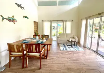 a living room with a wooden table and chairs at Paradiselodge - Casa Linda in Platanillo
