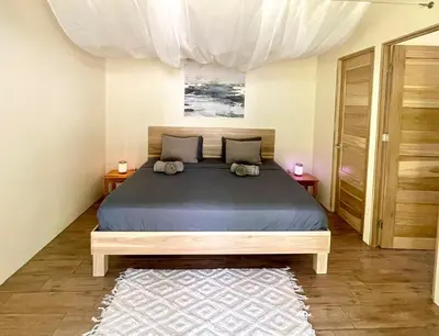a bedroom with a large bed and a rug at Paradiselodge - Casa Linda in Platanillo