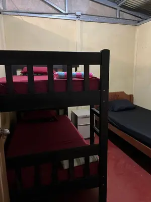 a room with three bunk beds in a room at Starfruit House in Chachagua