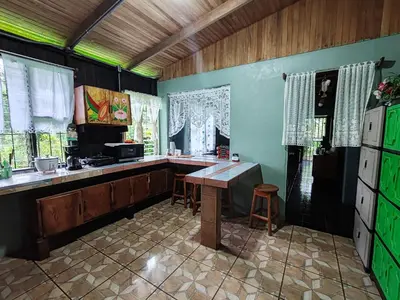 a kitchen with a counter and a table in it at Casa La Esperanza in Chachagua
