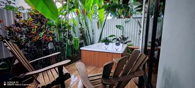 a patio with two chairs and a bathtub and plants at Bungalow Tucán & Jacuzzi in Fortuna