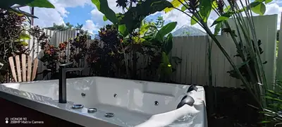 a white bath tub in a garden with plants at Bungalow Tucán & Jacuzzi in Fortuna