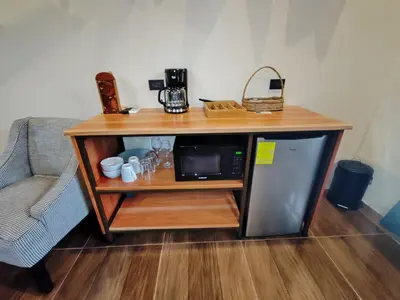 a small table with a microwave and a couch at Bungalow Tucán & Jacuzzi in Fortuna