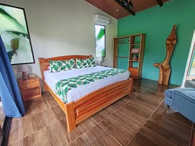 a bedroom with a bed in a room with green walls at Bungalow Tucán & Jacuzzi in Fortuna