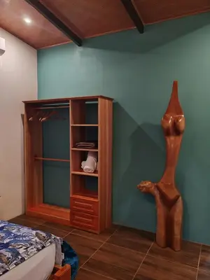 a bedroom with a wooden cabinet next to a bed at Bungalow Tucán & Jacuzzi in Fortuna