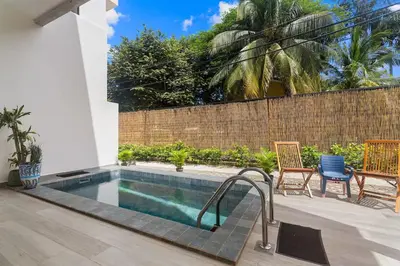 a swimming pool in a backyard with chairs and a fence at Chic Bohemian Villa with a Private Swimming Pool and Stunning Outdoor Space in Coco