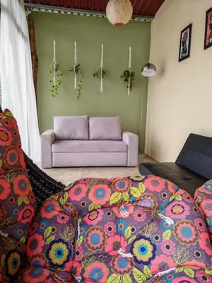 a living room with a couch and a bed at Tropical Crystal House in Guápiles