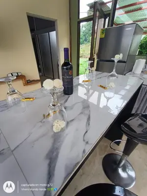 a table with glasses and a bottle of wine at Tropical Crystal House in Guápiles