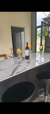 a bottle of wine sitting on a counter with wine glasses at Tropical Crystal House in Guápiles