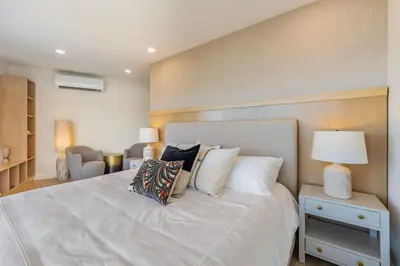 a bedroom with a large white bed with pillows at Stylish 1-BR Oceanfront Condo with Panoramic Views in Jacó