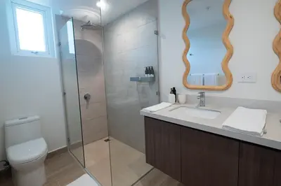 a bathroom with a toilet and a sink and a shower at Stylish 1-BR Oceanfront Condo with Panoramic Views in Jacó