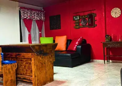 a living room with a couch and red walls at Peace of the forest in Llano Grande