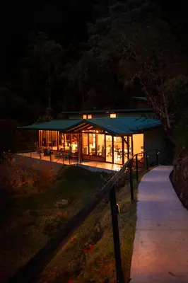a large building with a green roof at night at Hotel de Montaña Gema del Bosque in El Copey